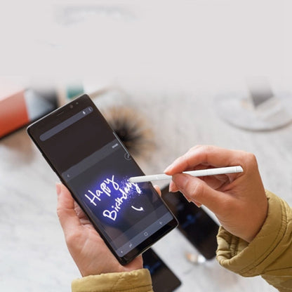 White touch stylus pen near a tablet screen, in a hand