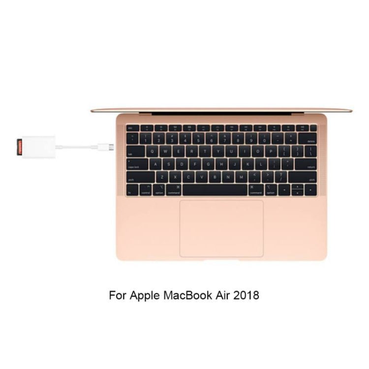 USB-C SD card reader adapter connected to a laptop with white cable