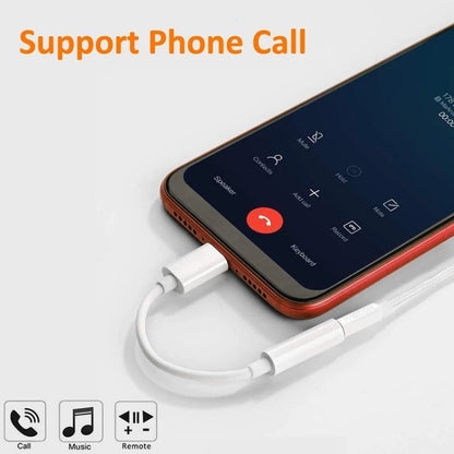 White USB-C to 3.5mm audio adapter cable plugged into a phone