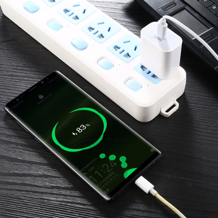 White 18W PD wall charger connected by cable, charging a phone via USB