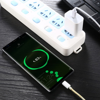 White 18W PD wall charger connected by cable, charging a phone via USB