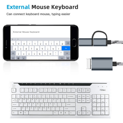 Grey OTG adapter cable connecting a phone to a keyboard or mouse, braided cord