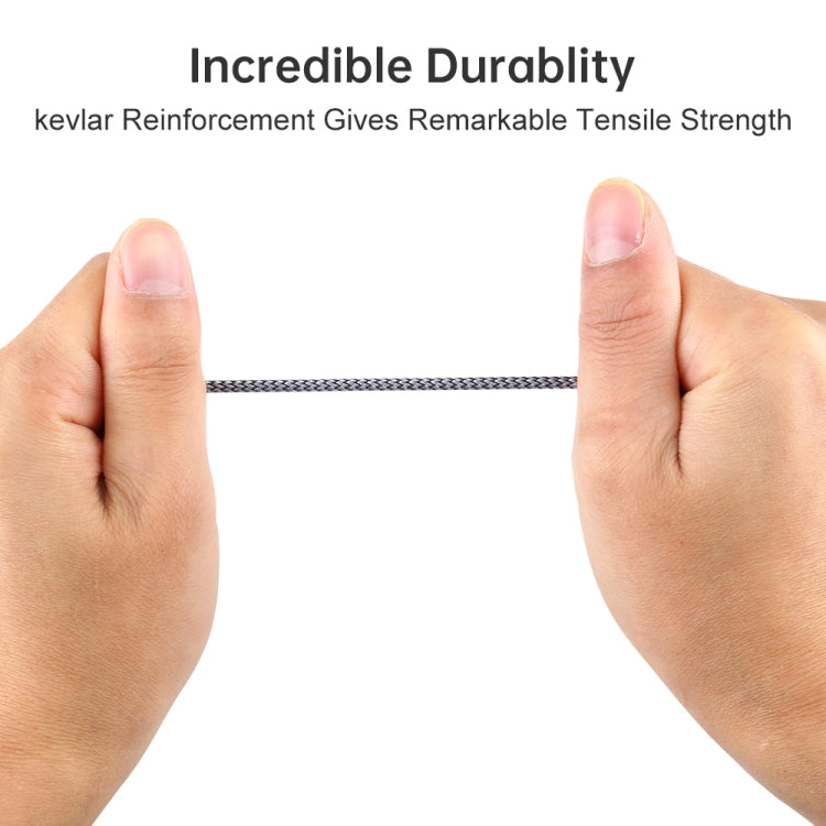 Grey braided audio cable held between fingers, showing reinforced braided section