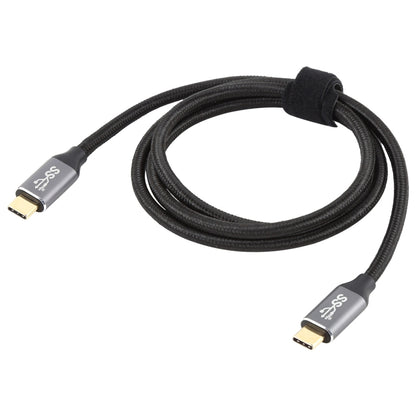 Coiled black braided USB-C male to USB-C male cable with gold connector tips.