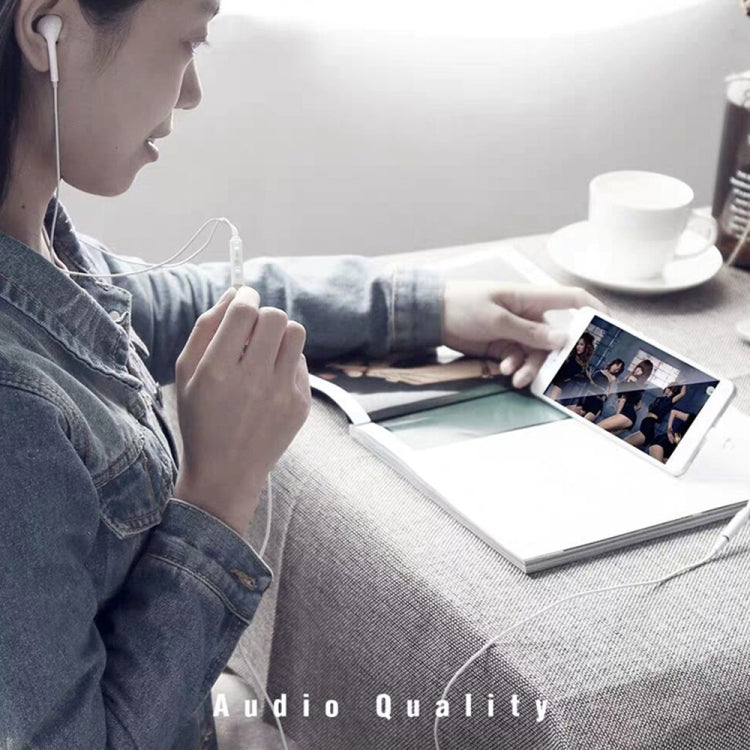 White USB-C to 3.5mm audio adapter connected to headphones and smartphone