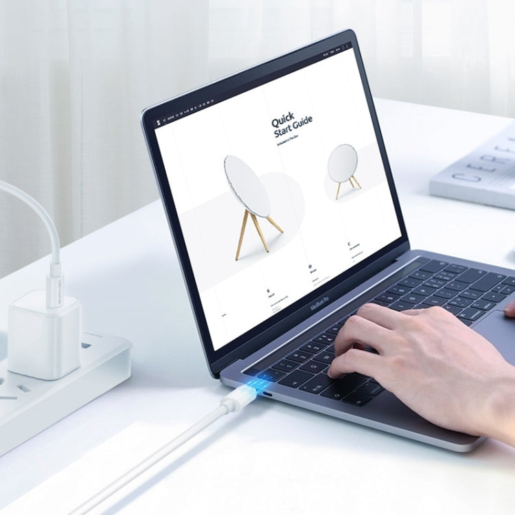 White USB-C to USB-C charging cable plugged into a laptop