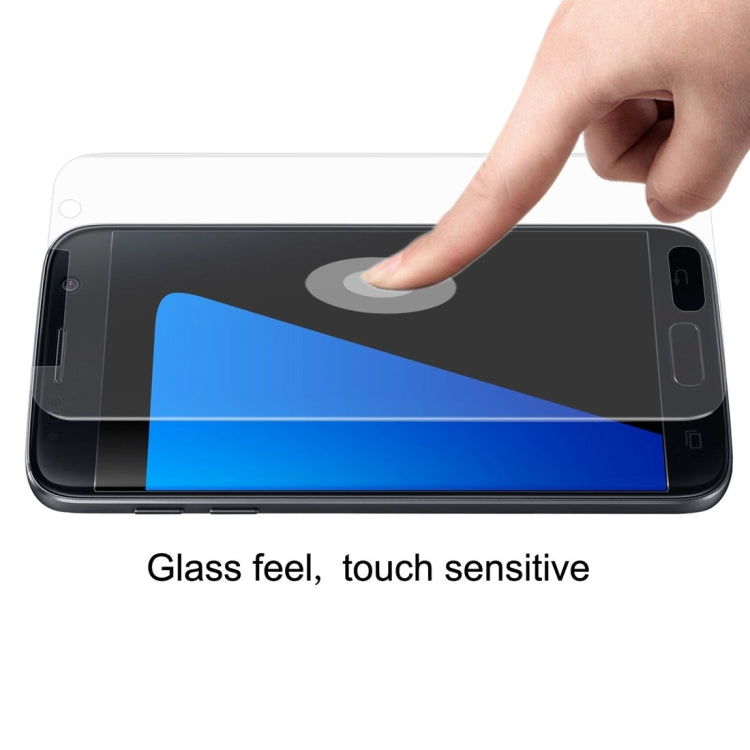 Hand smoothing transparent screen protector over dark Galaxy phone touchscreen