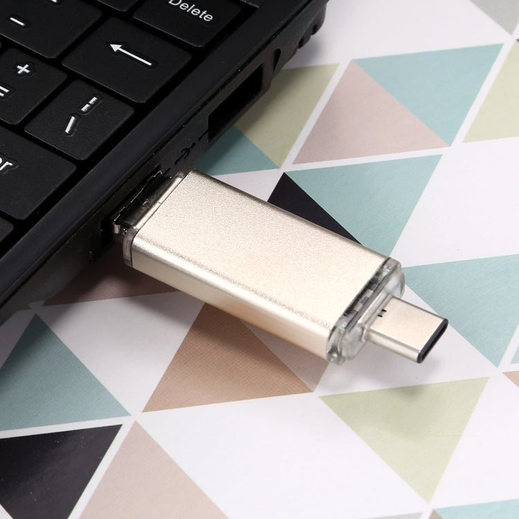 Gold 128GB USB flash drive plugged into laptop USB Type-A port