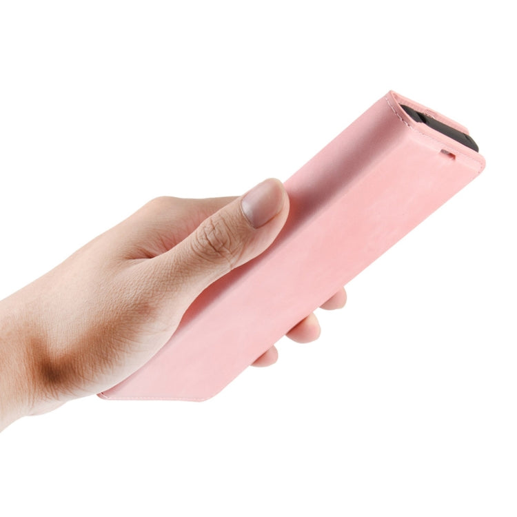 Pink leather folio phone case held in hand, showing magnetic flap tab