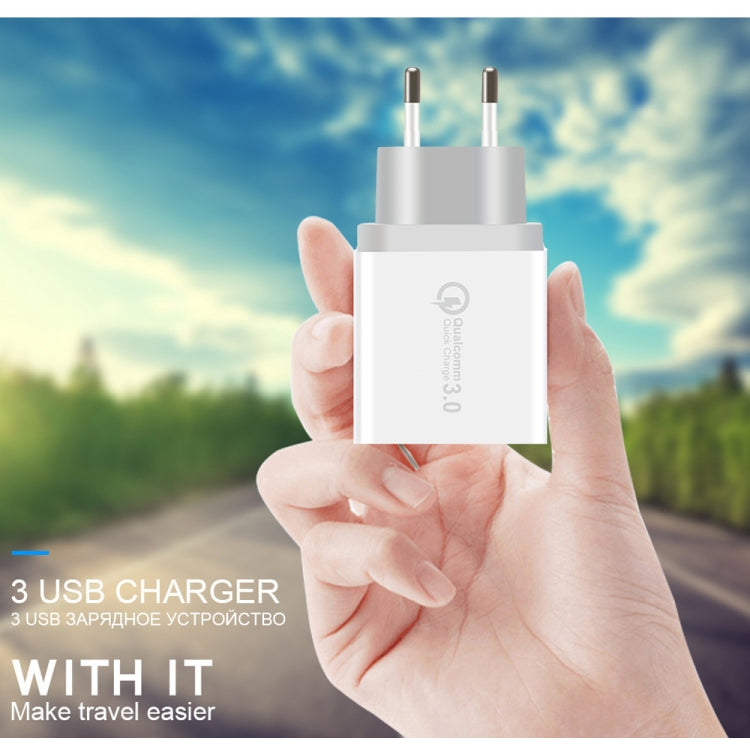 White EU USB charger held in hand with dual plug prongs