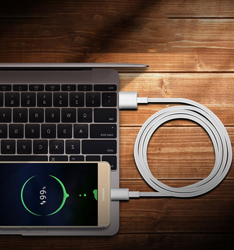 White USB-C cable connected to a laptop on a wooden desk