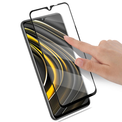 Tempered glass screen protector being applied to phone screen by hand