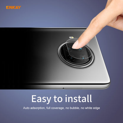 Tempered glass rear camera lens protector film being aligned by a fingertip on the phone