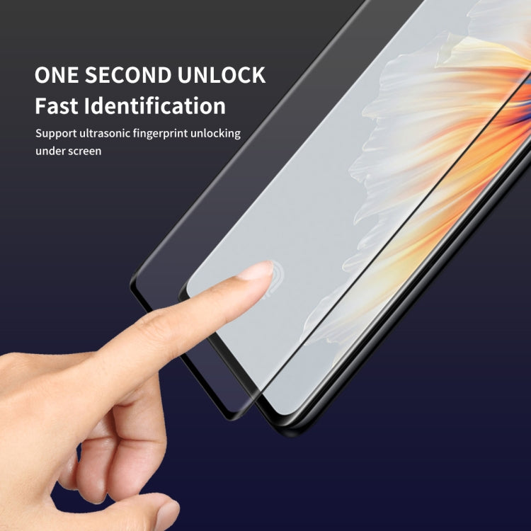 Hand applying curved tempered glass screen protector to Xiaomi Mix 4, full coverage