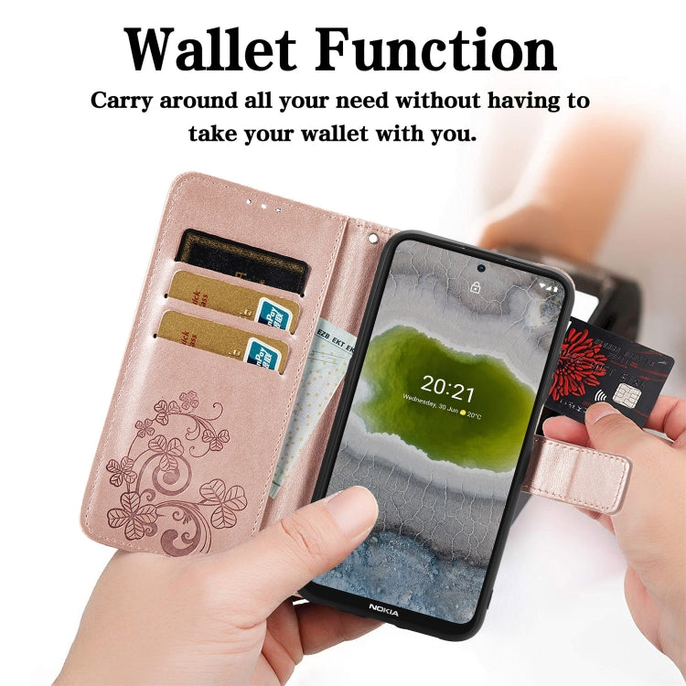 Pink leather wallet phone case with floral embossed pattern, card slots, held in hand