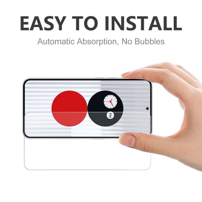 Tempered glass screen protector being applied to smartphone screen by hand