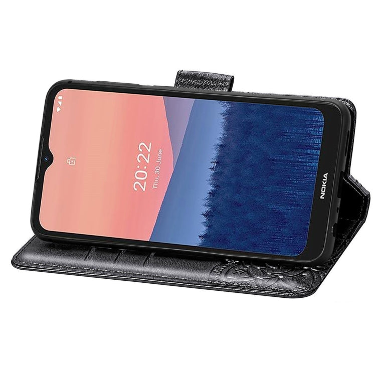 Black flip phone case with embossed butterfly and floral pattern, phone in landscape stand