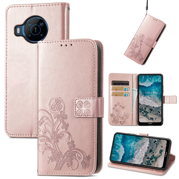 Light pink leather phone case with embossed floral design, clasp strap, and card slots