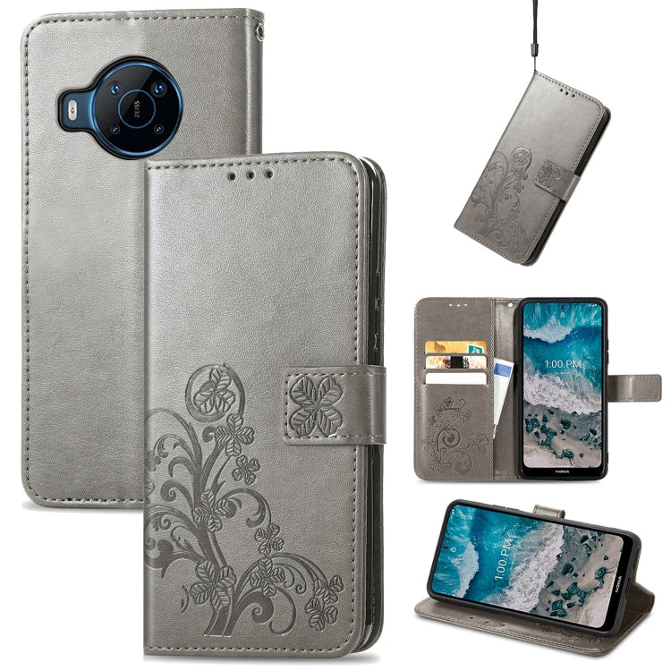 Gray leather flip phone case with embossed floral four-leaf clasp and buckle closure
