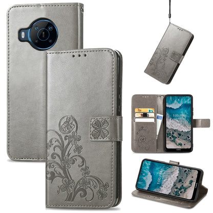 Gray leather flip phone case with embossed floral four-leaf clasp and buckle closure