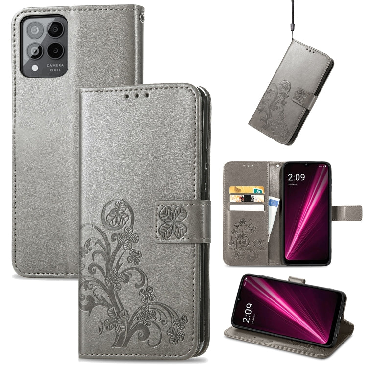 Gray leather flip phone case with embossed floral clover, clasp buckle, and stand