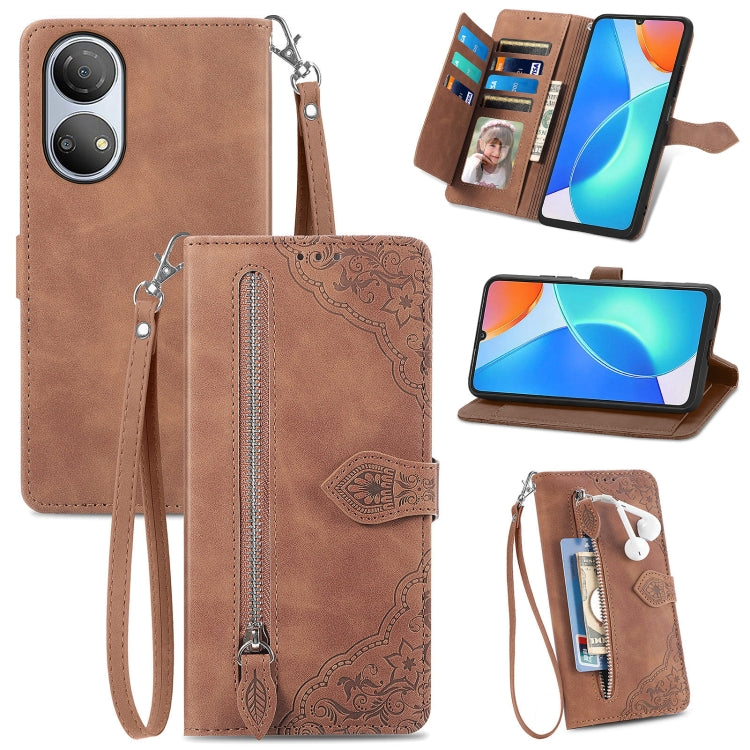 Brown leather phone wallet case with embossed floral pattern, zipper, and wrist strap