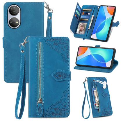 Blue leather phone wallet case with embossed floral pattern, zipper, and wrist strap