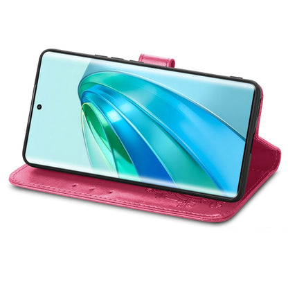 Magenta leather folio phone case with embossed floral design and clasp buckle stand