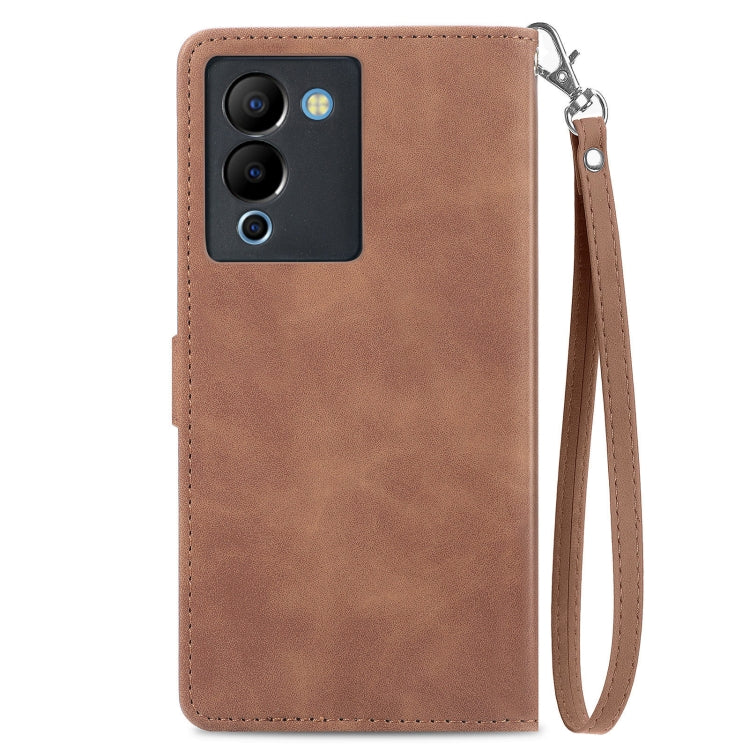 Brown leather phone case with embossed floral design, zipper closure, and wrist strap