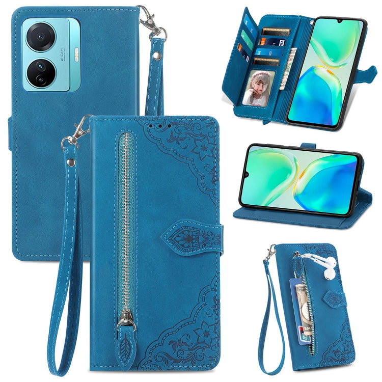 Blue leather phone wallet case with embossed flower design, zipper compartment, wrist strap.