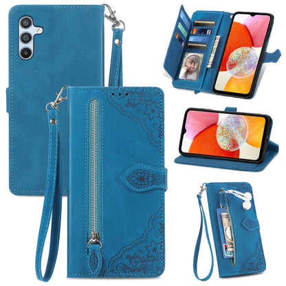 Blue leather phone wallet case with embossed flower texture, zipper pull, wrist strap, slots.