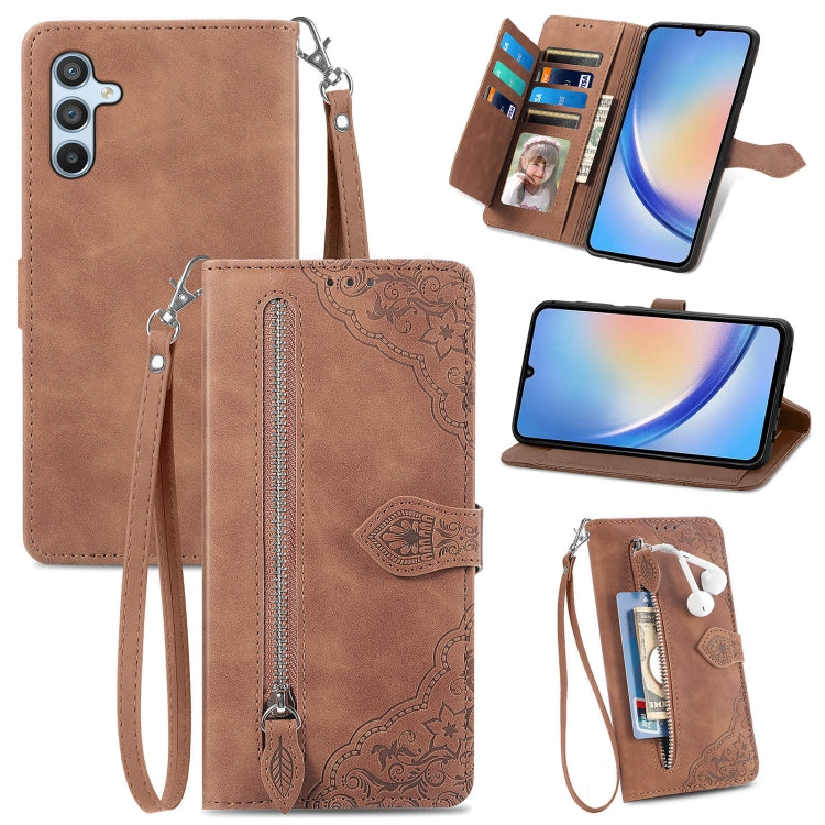 Brown leather phone wallet case with embossed flower pattern, zipper, wrist strap, card slots.