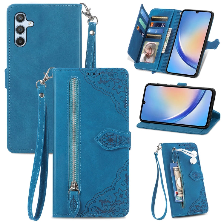 Blue leather phone wallet case with embossed floral design, zipper closure, wrist strap, slots.