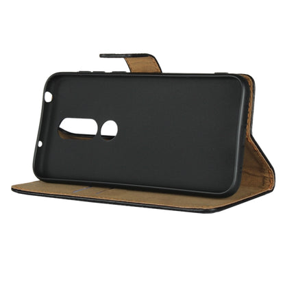 Black leather flip holster wallet holding phone, showing camera cutout.