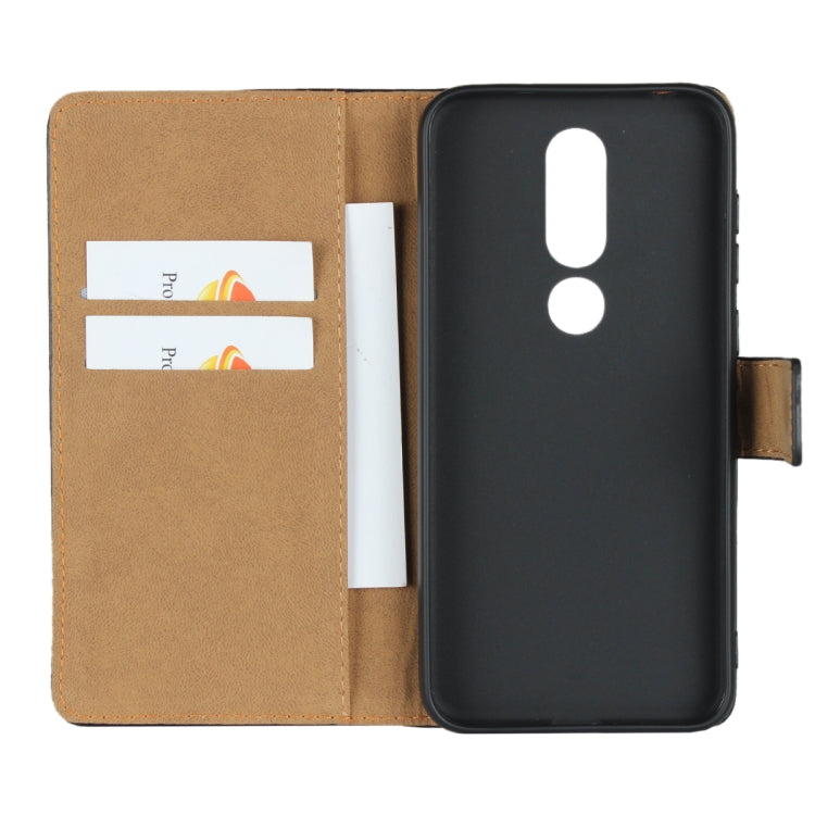 Black and tan leather flip holster wallet with two card slots inside.