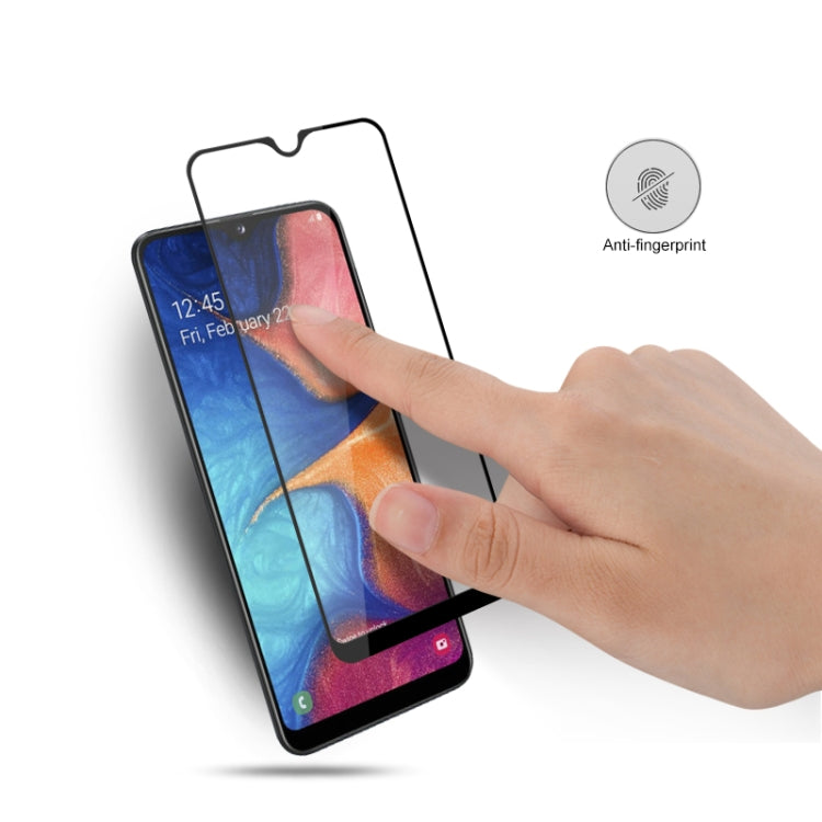 Tempered glass screen protector film being applied to smartphone screen by hand