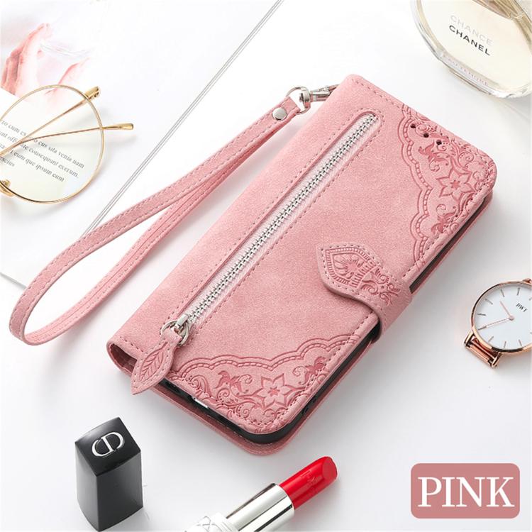Pink leather phone case with embossed floral pattern, wrist strap, and zipper