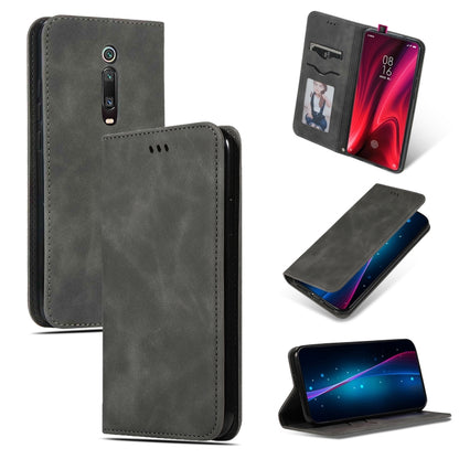 Dark gray magnetic flip wallet phone case with stitched edges and camera cutout.