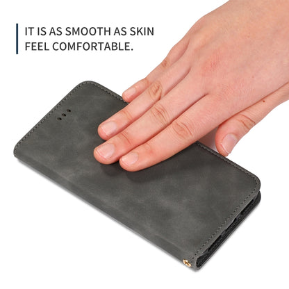 Dark gray leather flip phone case with hand pressing the front cover, stitched sides.