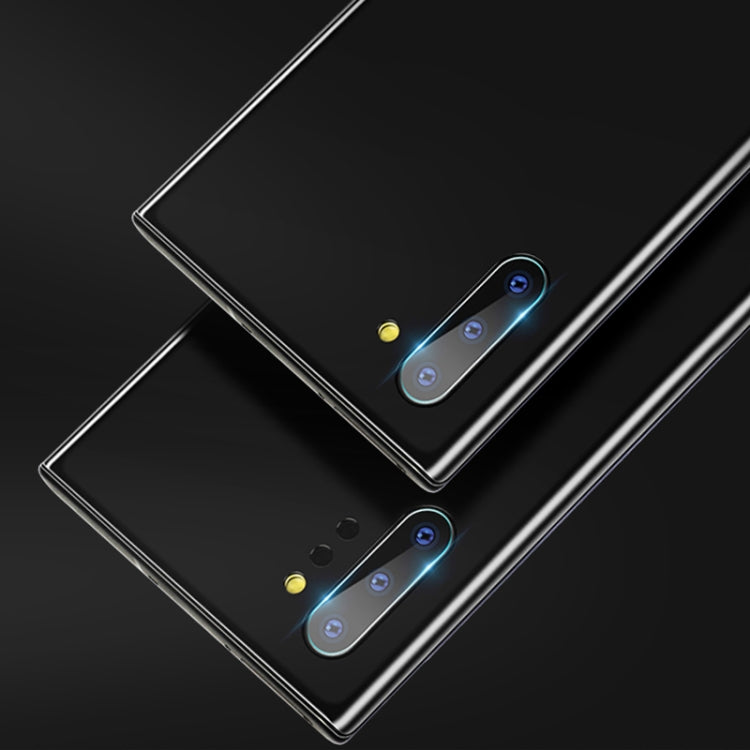 Two tempered glass camera lens protector sheets with blue alignment glow on phone backs