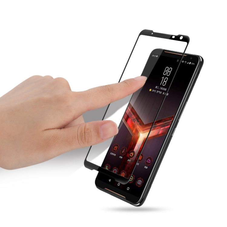 Tempered glass screen protector installation on Asus ROG Phone II, hand applying