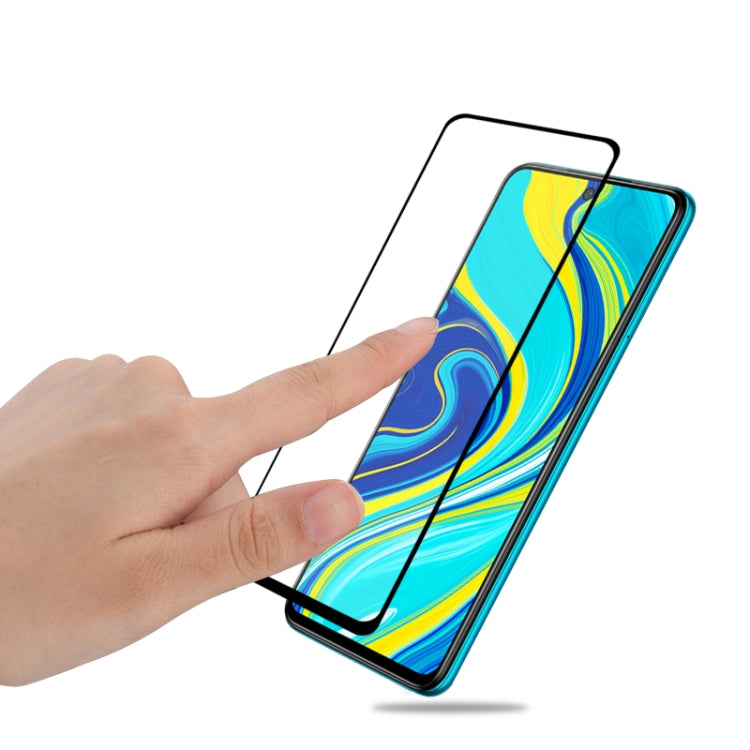 Xiaomi Redmi Note 9s tempered glass screen protector being applied by hand