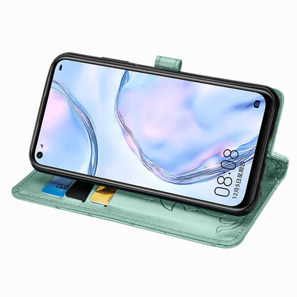 Mint green folio phone case folded to prop up the phone screen, cat-and-dog embossing.