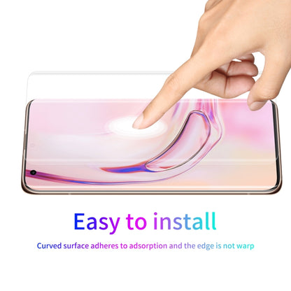 Curved transparent screen protector film being smoothed onto a smartphone screen