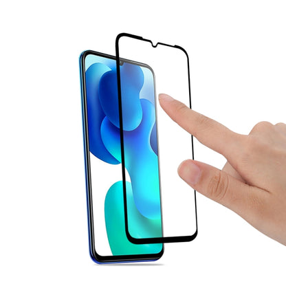 Curved tempered glass screen protector for Xiaomi Mi 10 Lite being applied by hand