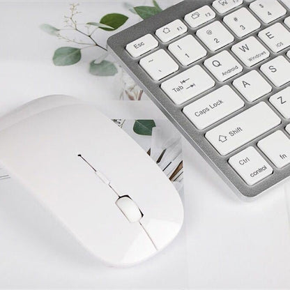Silver mini wireless Bluetooth keyboard beside a white wireless Bluetooth mouse