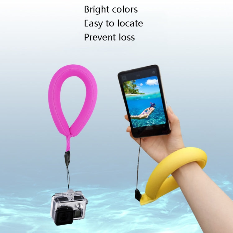 Buoyant diving wrist float with lanyard, pink band holding action camera