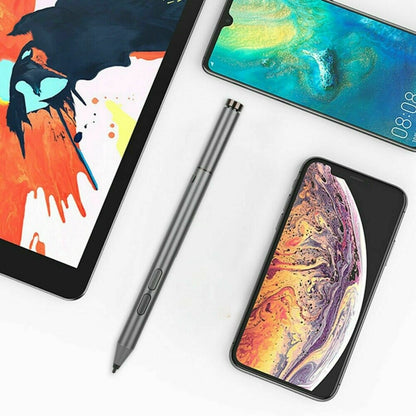 Gray Bluetooth stylus pen beside tablet devices, angled.