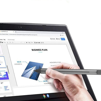 Hand holding a metallic stylus pen to draw on a tablet screen