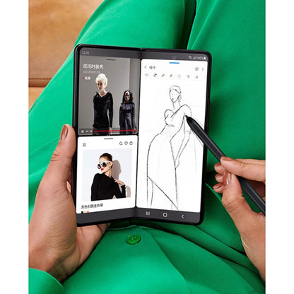 Hands using black stylus pen to draw on Samsung Fold4 tablet display